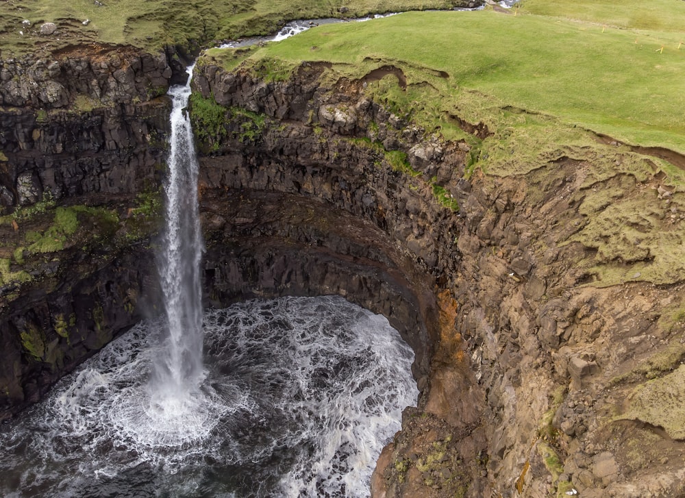 waterfalls on brown rocky mountain during daytime