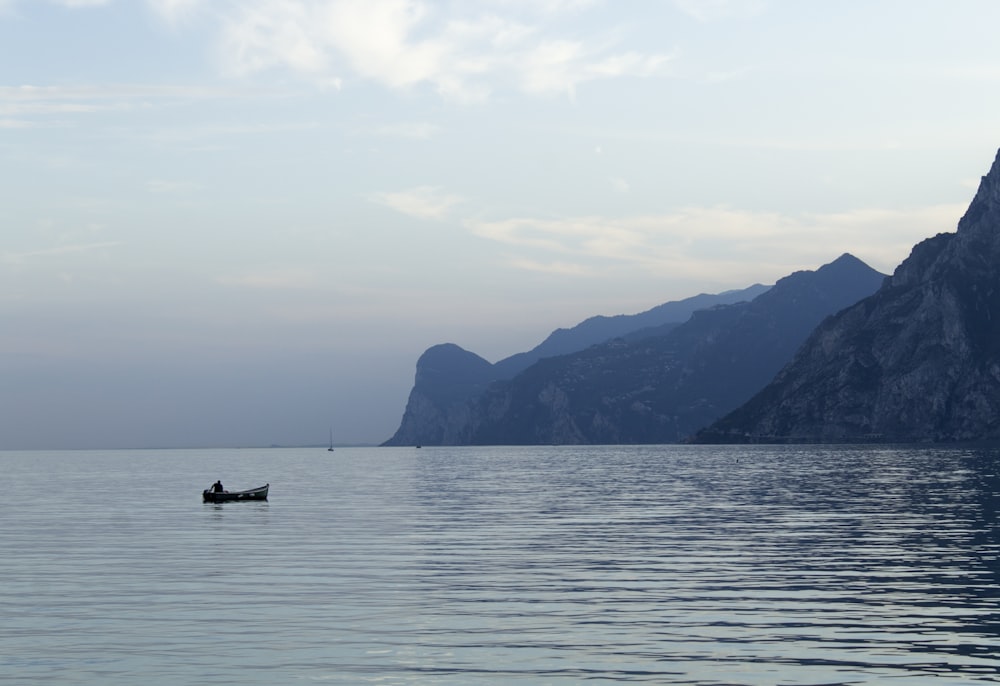 silhouette of person riding on boat on sea during daytime