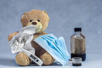 brown bear plush toy on blue textile
