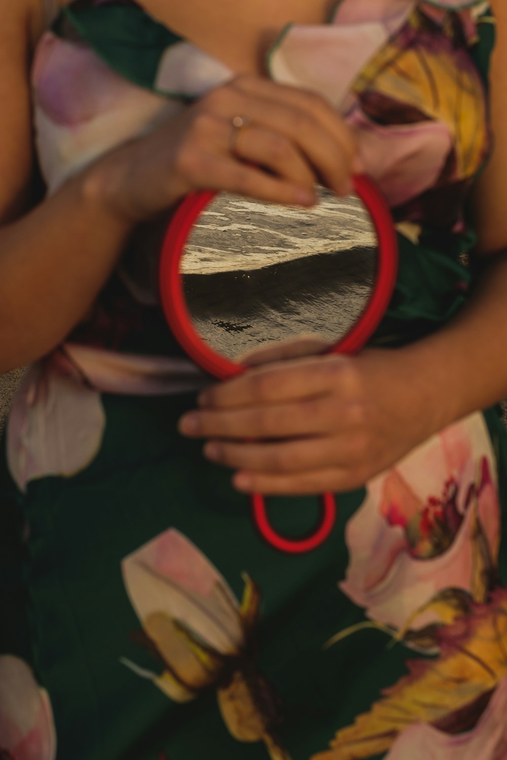 person holding red round frame