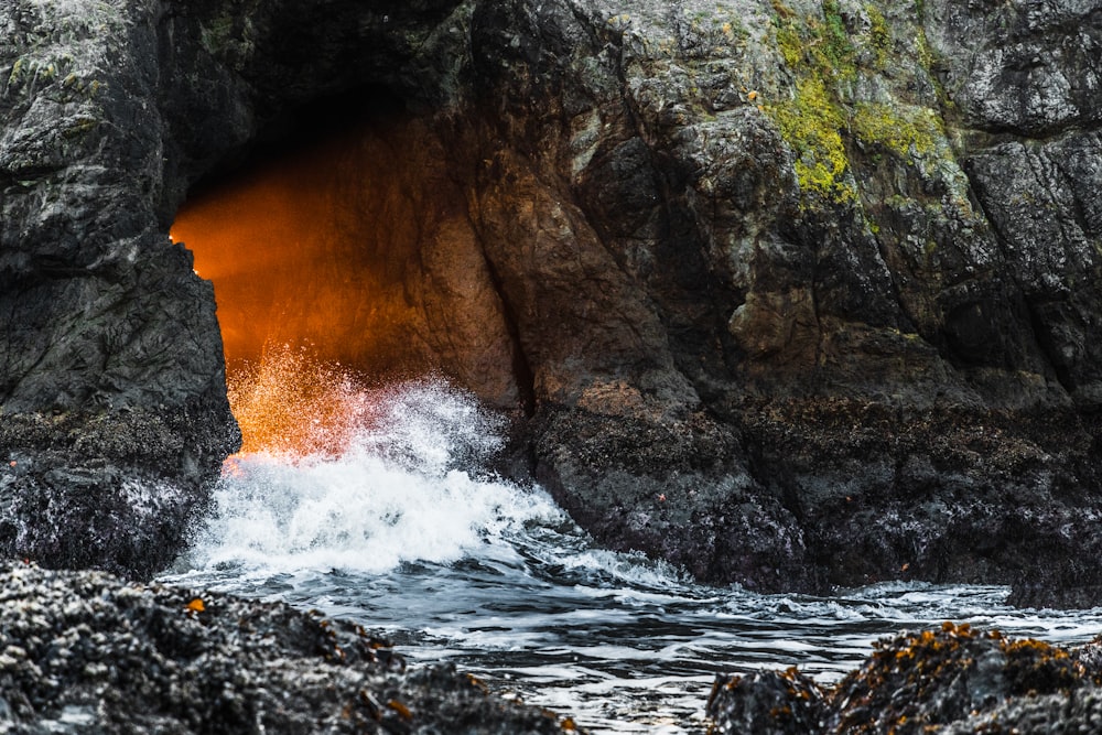 Le onde d'acqua colpiscono le rocce durante il giorno