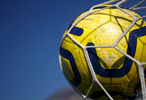 Close-up of a soccer ball hitting the net during an intense match.