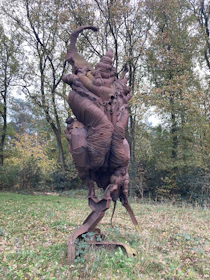 Minimalist sculpture displayed outdoors, blending natural elements with modern design.
