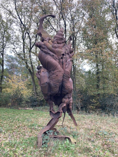 Minimalist sculpture displayed outdoors, blending natural elements with modern design.