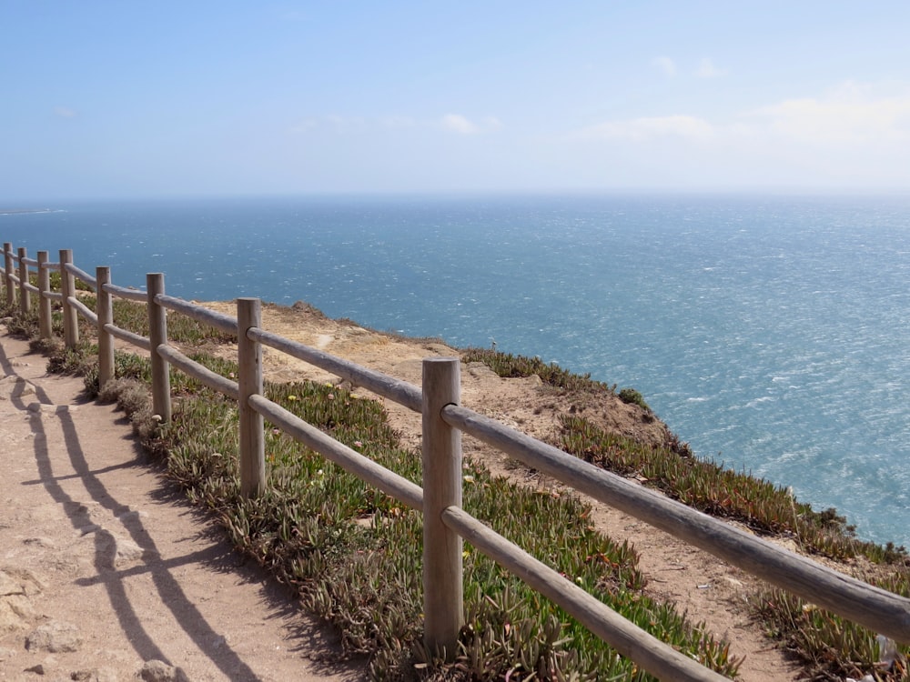 brown wooden fence near sea during daytime