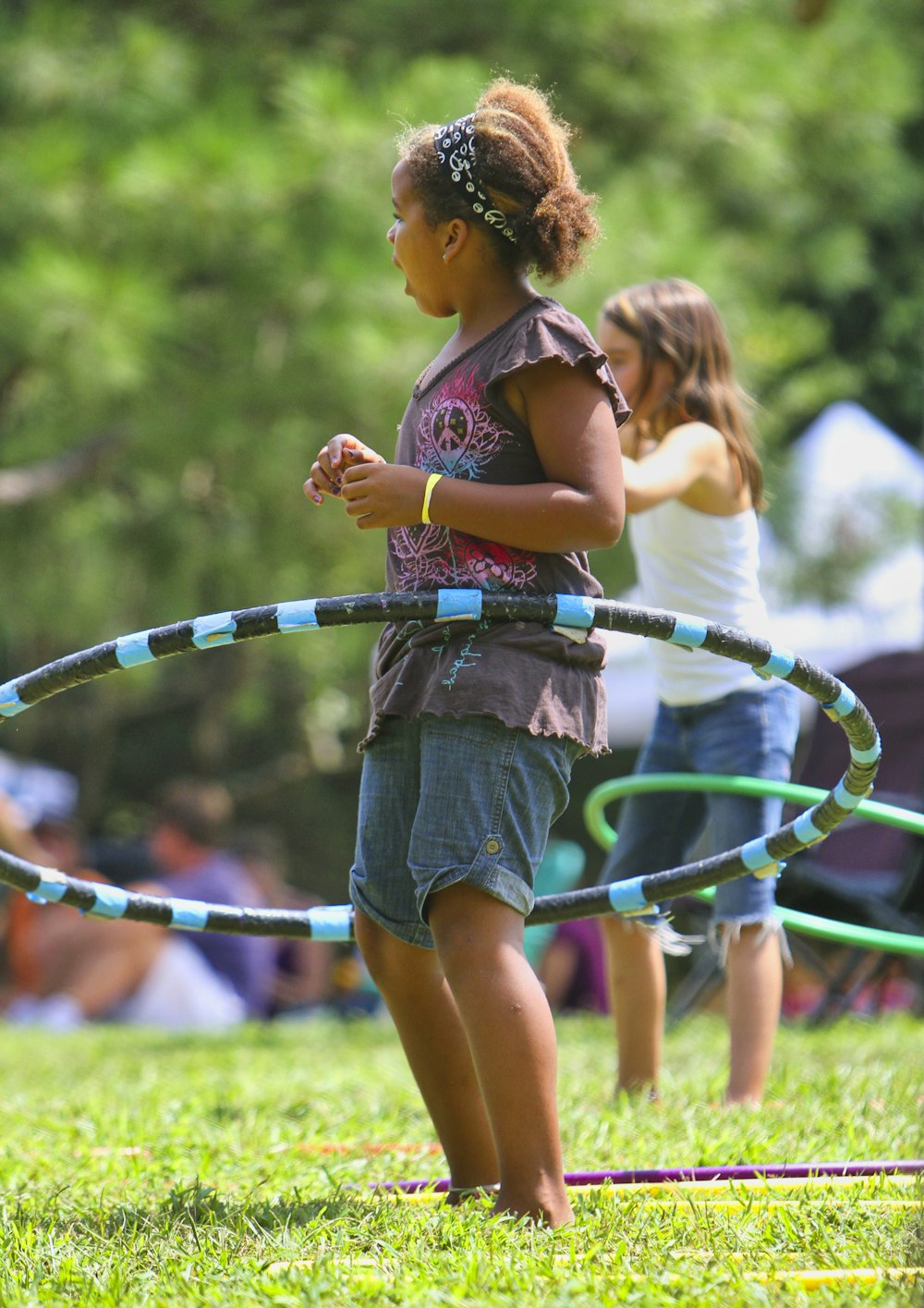 menina em shorts jeans azuis segurando corda verde e azul