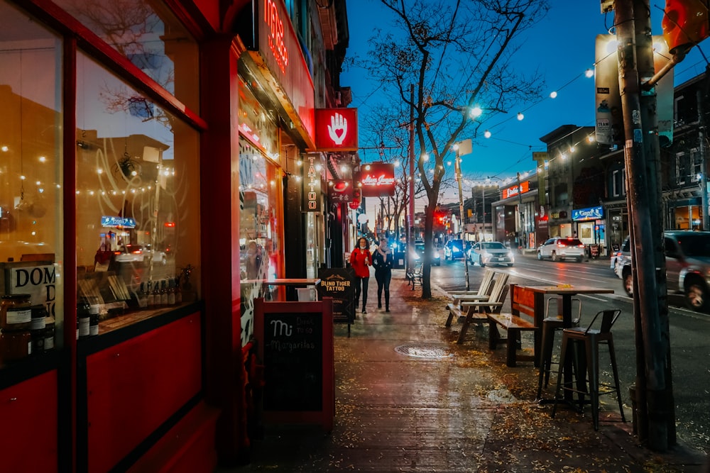 people walking on sidewalk during night time