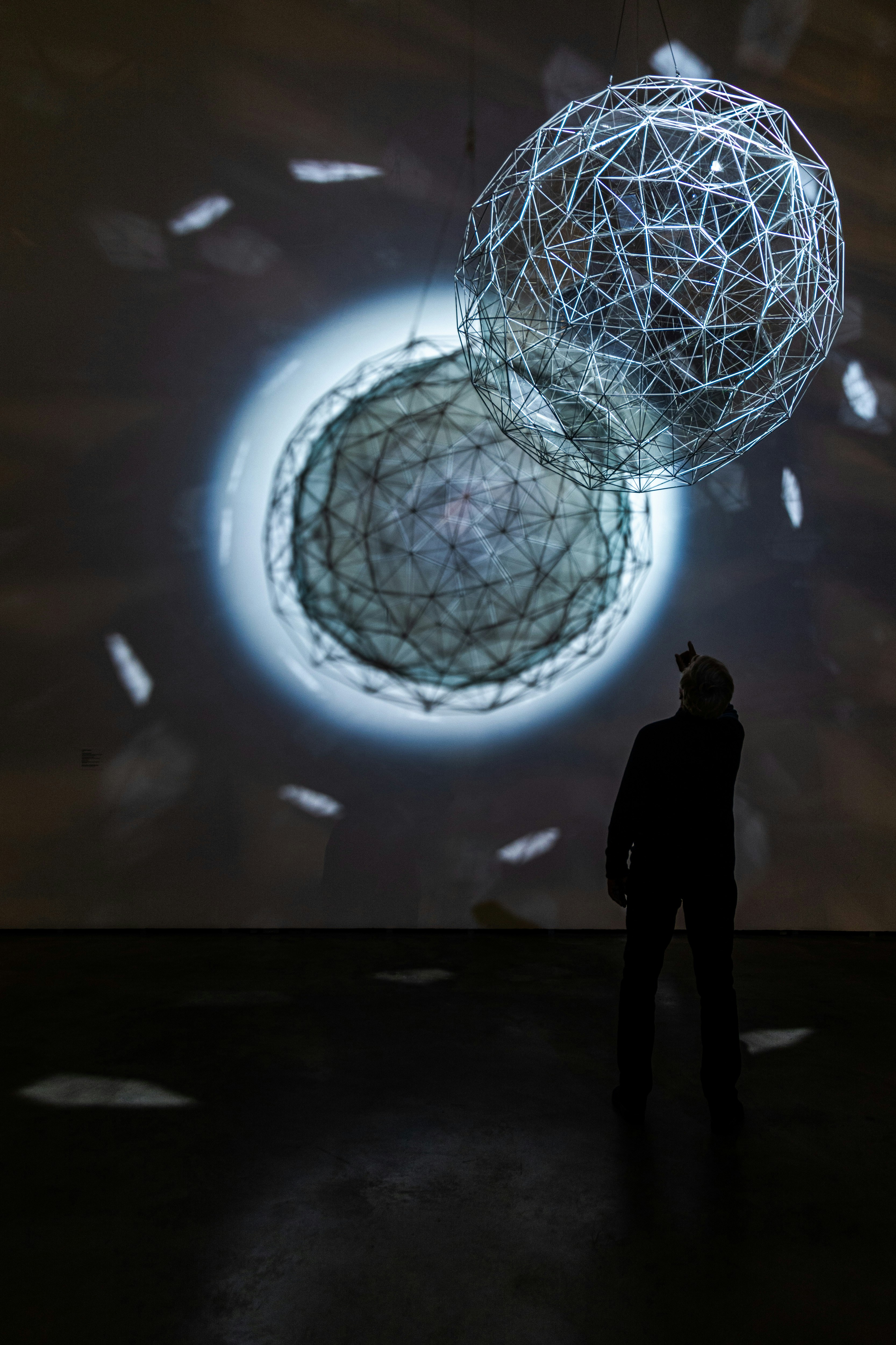 silhouette of person standing near white round ball