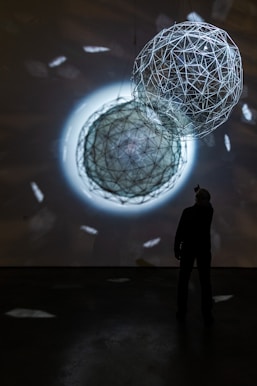 silhouette of person standing near white round ball