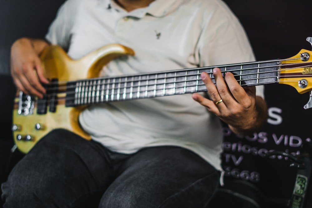 person playing electric guitar while sitting