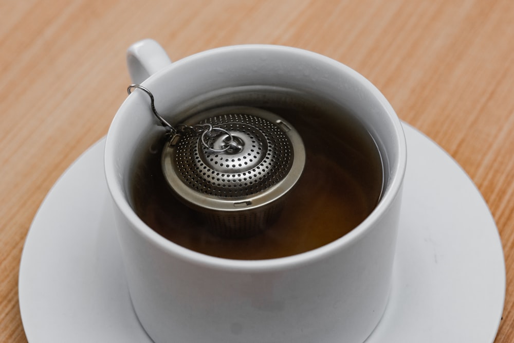 silver round accessory on white ceramic mug