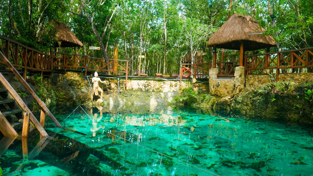 people in swimming pool near brown wooden house during daytime