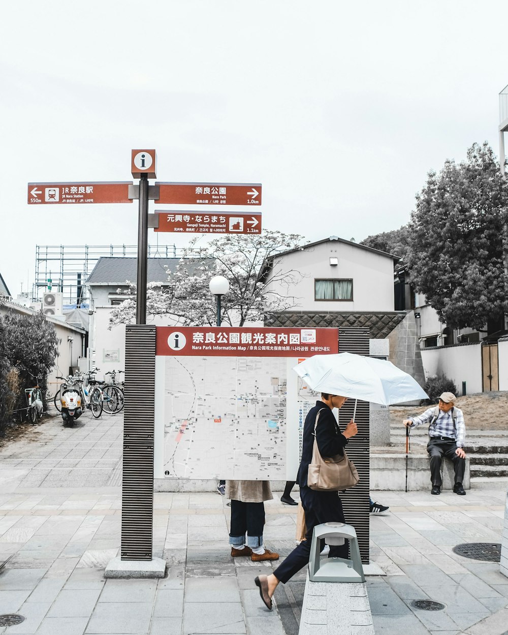 people walking on sidewalk with umbrella during daytime