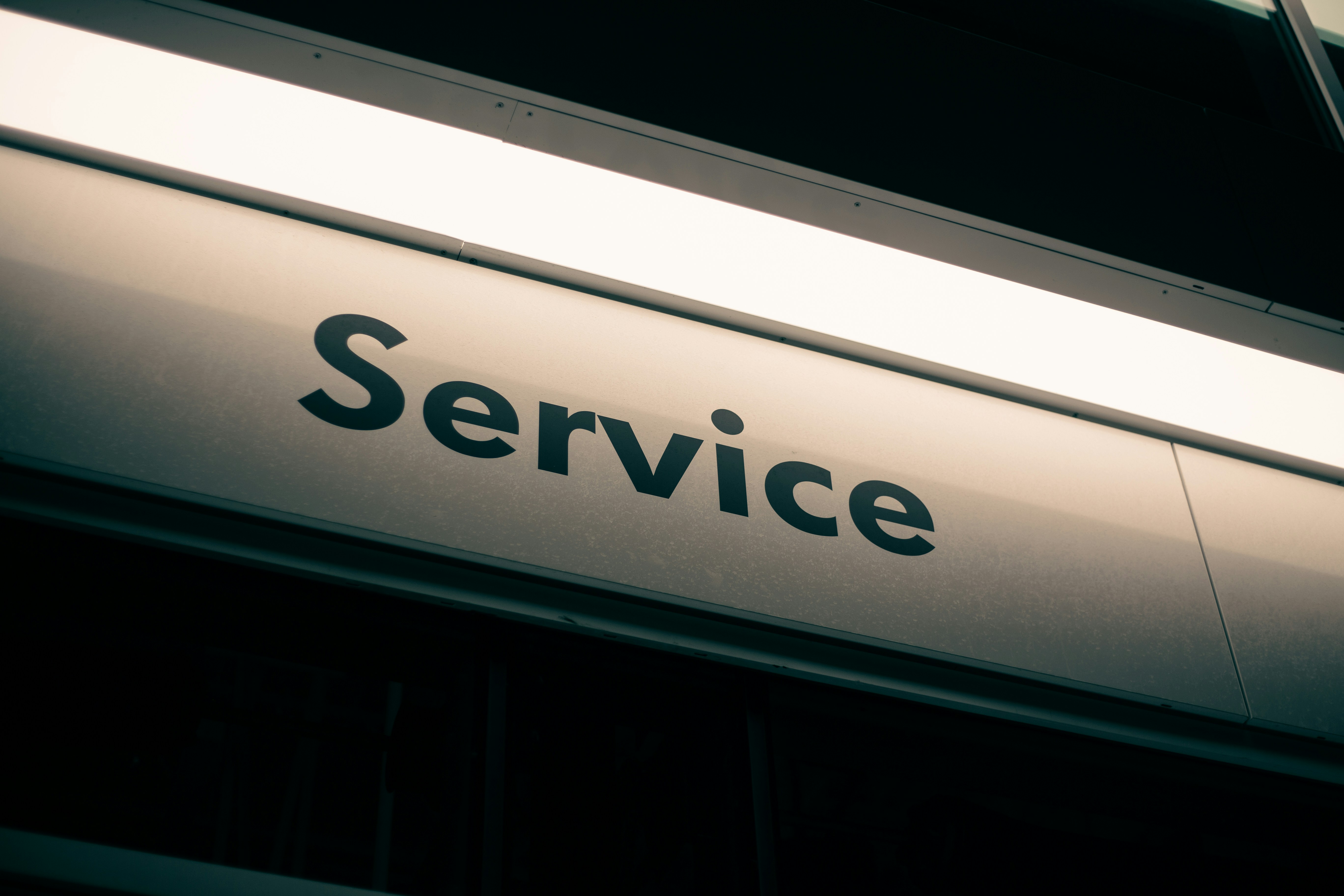 A sign with the word Service in black letters on a white background