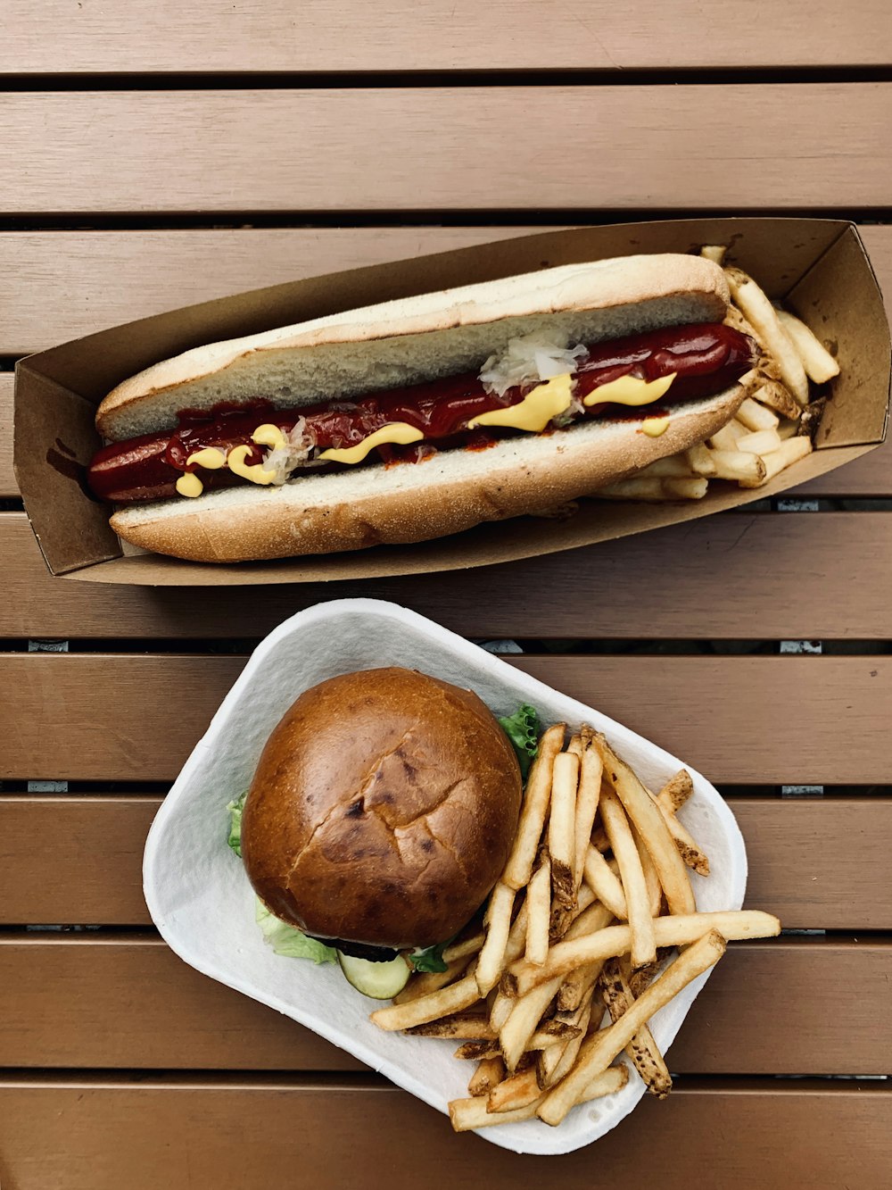 hotdog sandwich with fries on brown wooden table