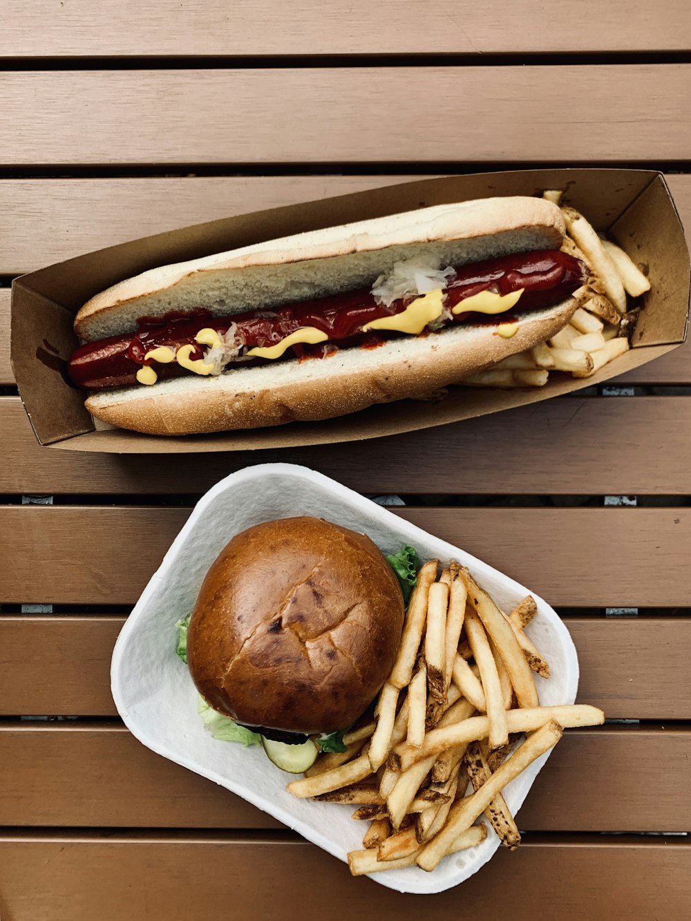 Hotdog Sandwich mit Pommes auf braunem Holztisch