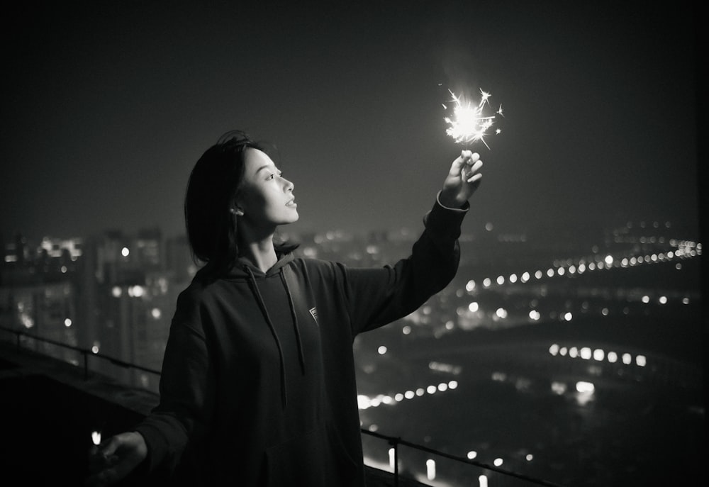 woman in gray coat holding sparkler