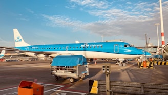 blue and white passenger plane on airport during daytime