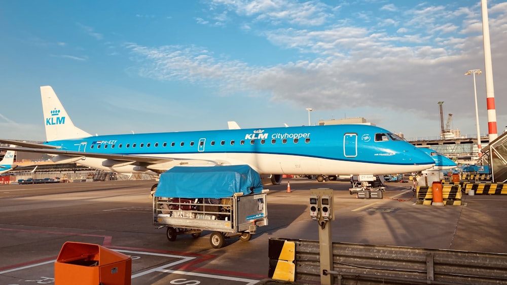 blue and white passenger plane on airport during daytime