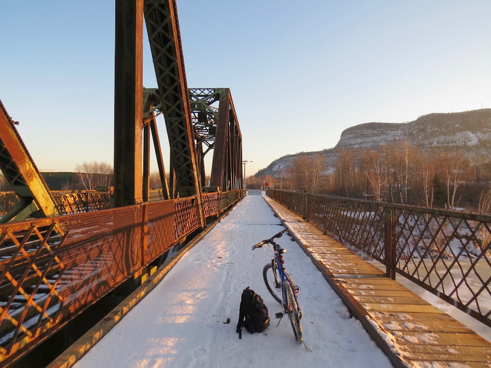 person riding bicycle on bridge during daytime