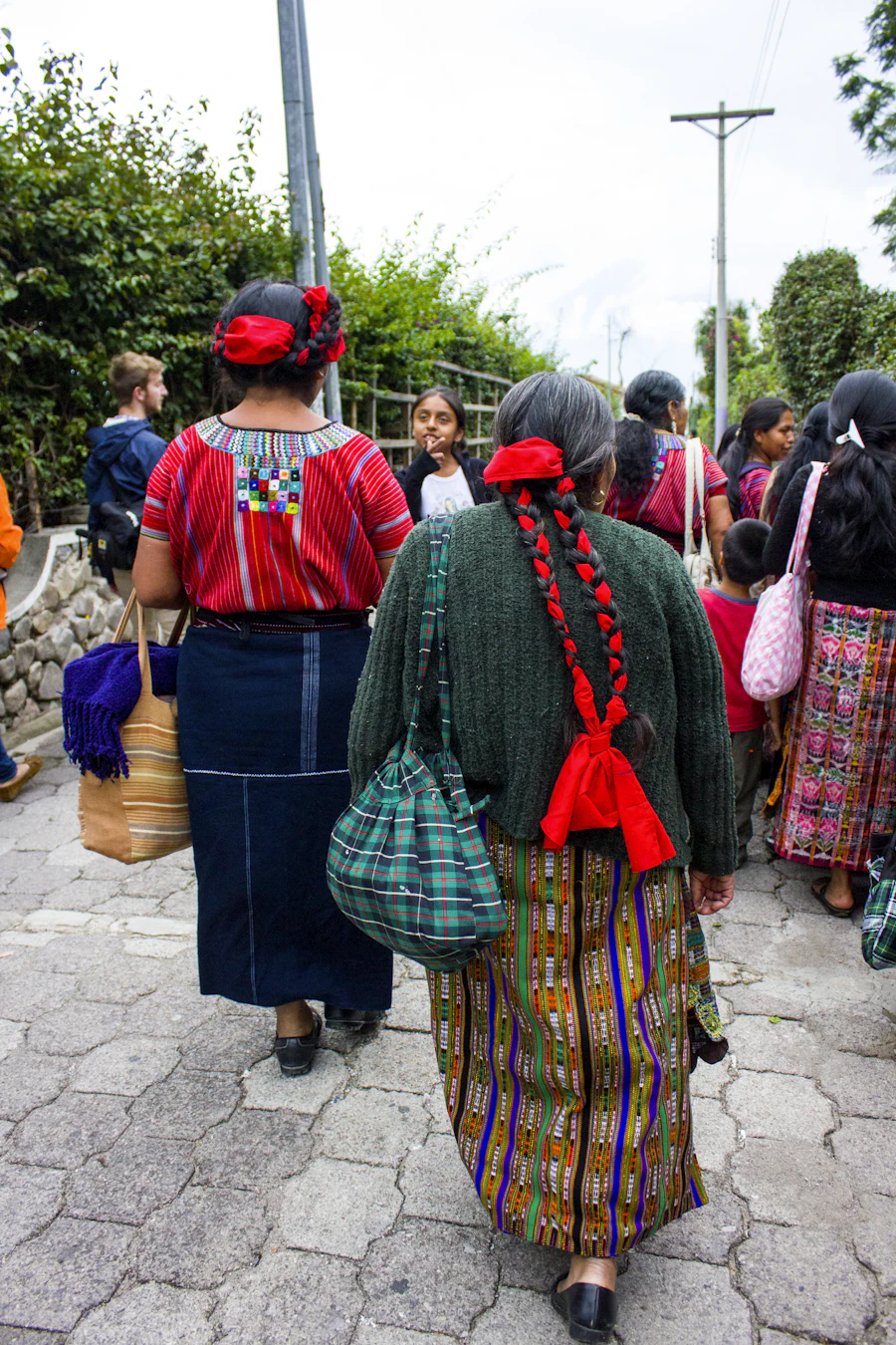 Reunión de tejedoras mayas con traje tradicional en una calle de Santa Catarina Palopó (personas reconocibles).