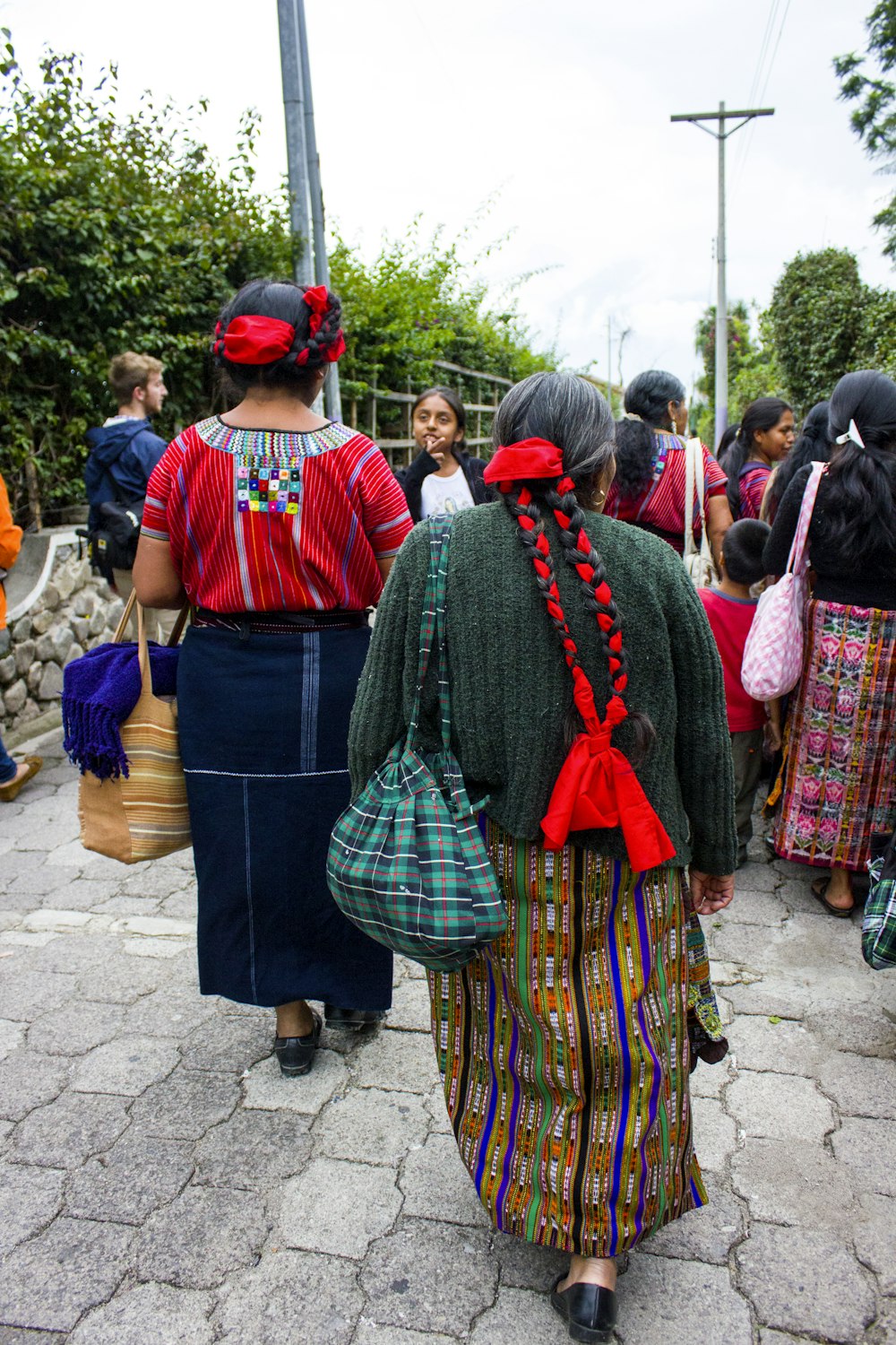 people in red and blue traditional dress walking on street during daytime