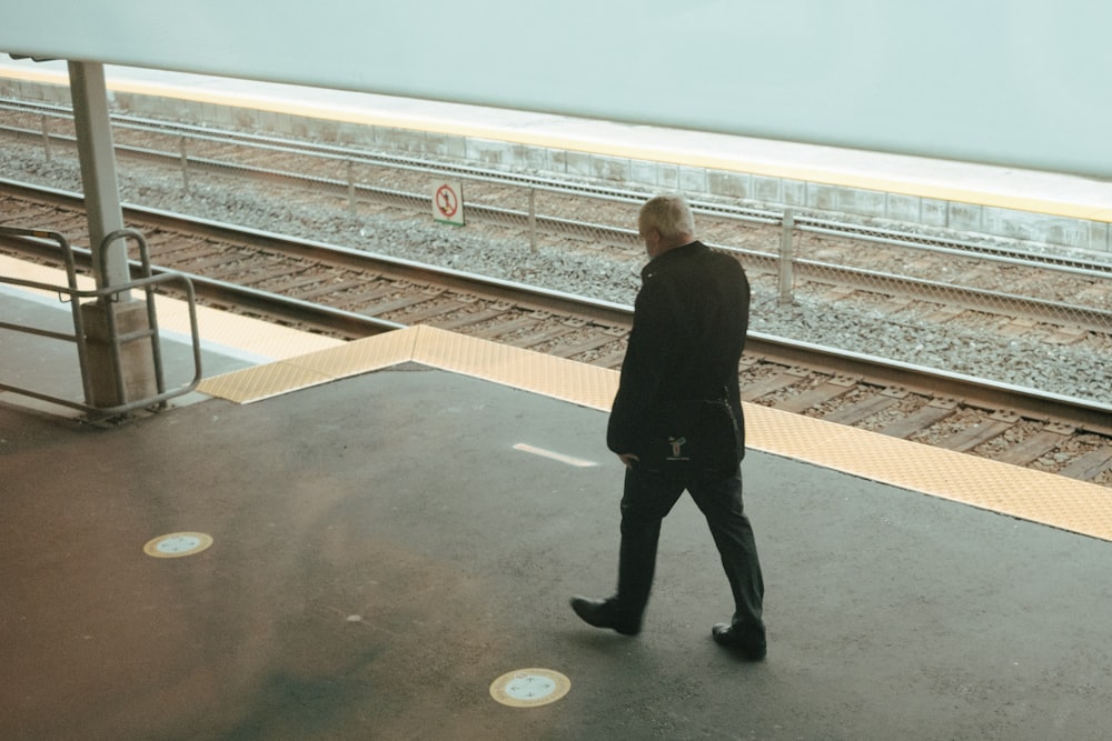 man in black jacket standing on the edge of a building