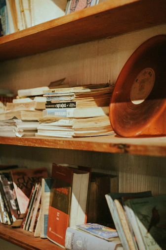 A vintage wooden shelf displaying pre-loved books and trinkets.