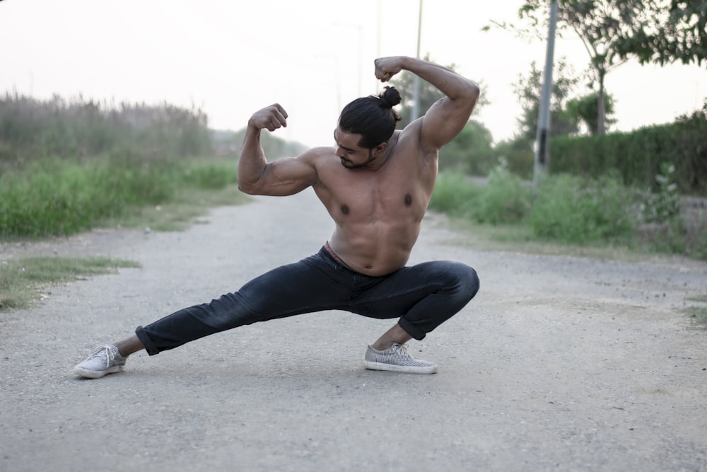 man in blue denim jeans and black nike shoes doing push up