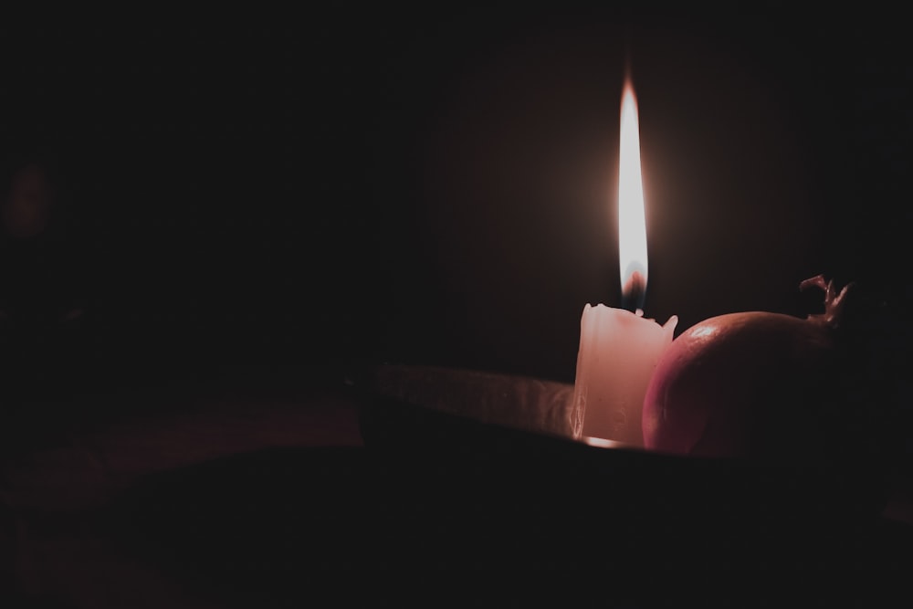 lighted candle in dark room