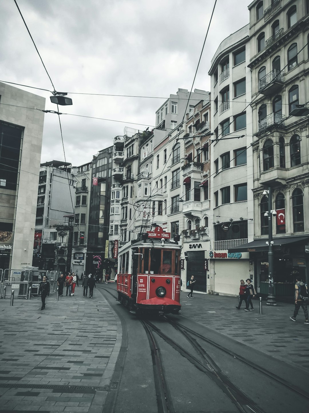 red tram on road near buildings during daytime