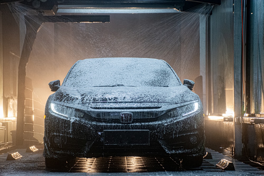 Un coche está cubierto de nieve en un garaje