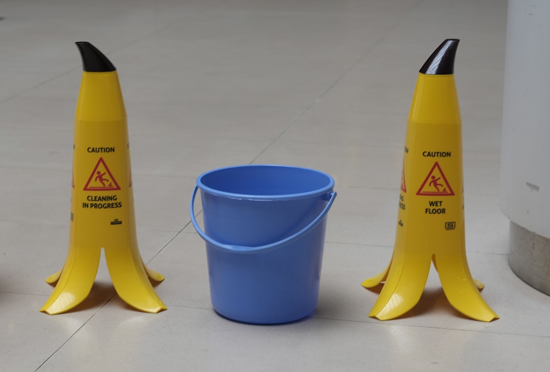  yellow and black plastic bottle beside blue plastic cup bucket
