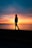 silhouette of woman standing on seashore during sunset
