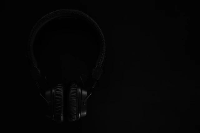 black and gray headphones on black surface