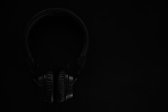 black and gray headphones on black surface