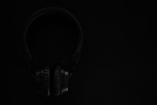 black and gray headphones on black surface