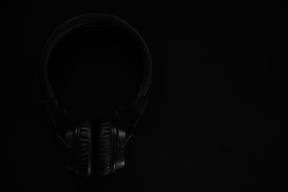 black and gray headphones on black surface