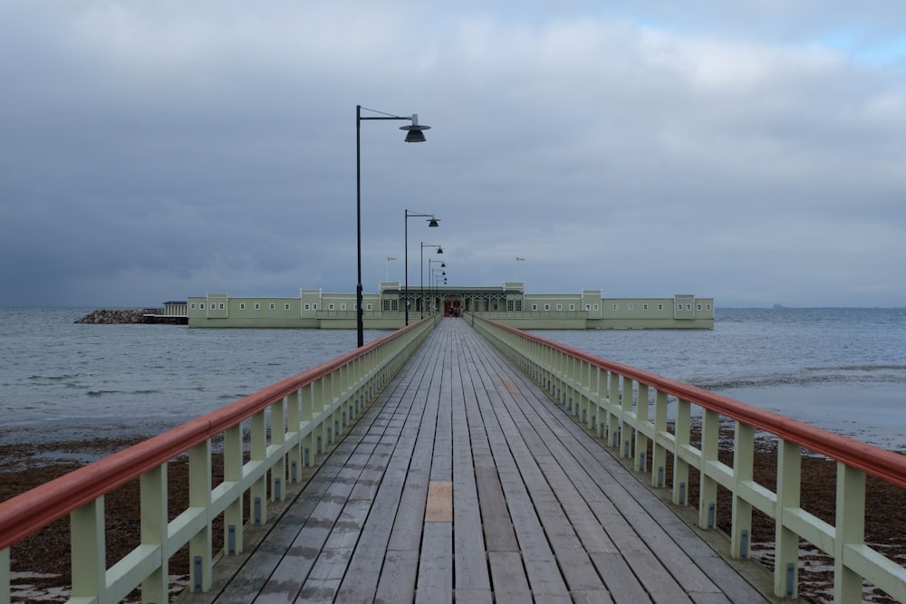 muelle de madera marrón en el mar bajo el cielo gris durante el día