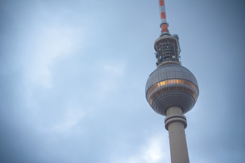 white and red tower under white clouds