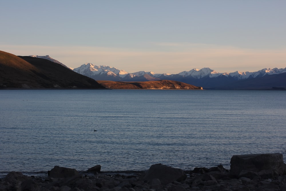 body of water near mountain during daytime