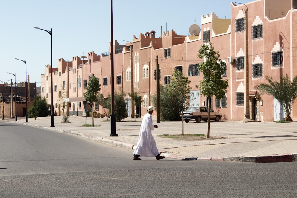 woman in white dress walking on sidewalk during daytime