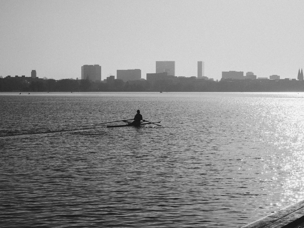Silhouette eines Mannes, der tagsüber auf einem Boot auf einem Gewässer fährt