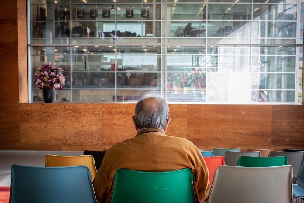 man in orange polo shirt sitting on chair