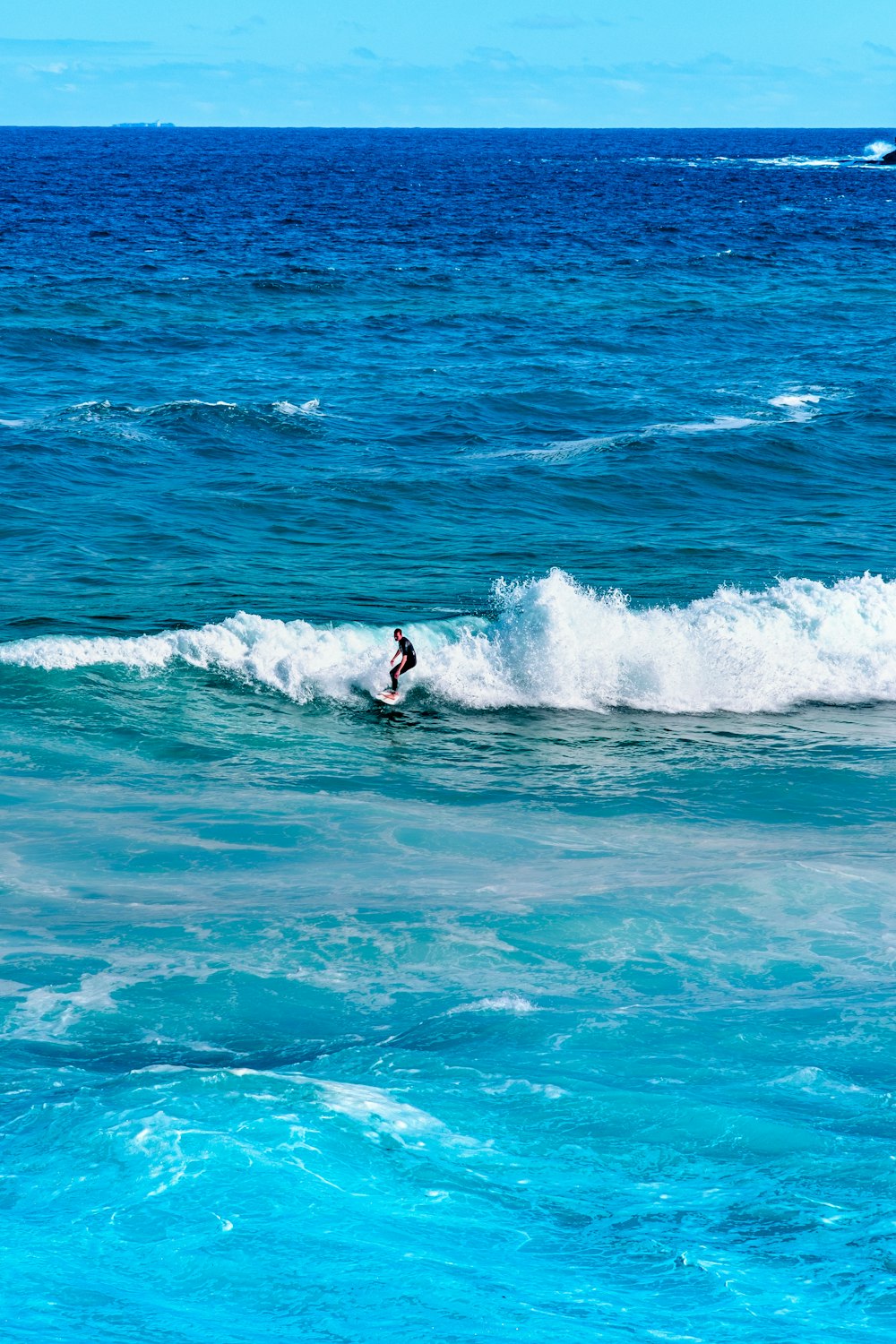 homme surfant sur les vagues de la mer pendant la journée