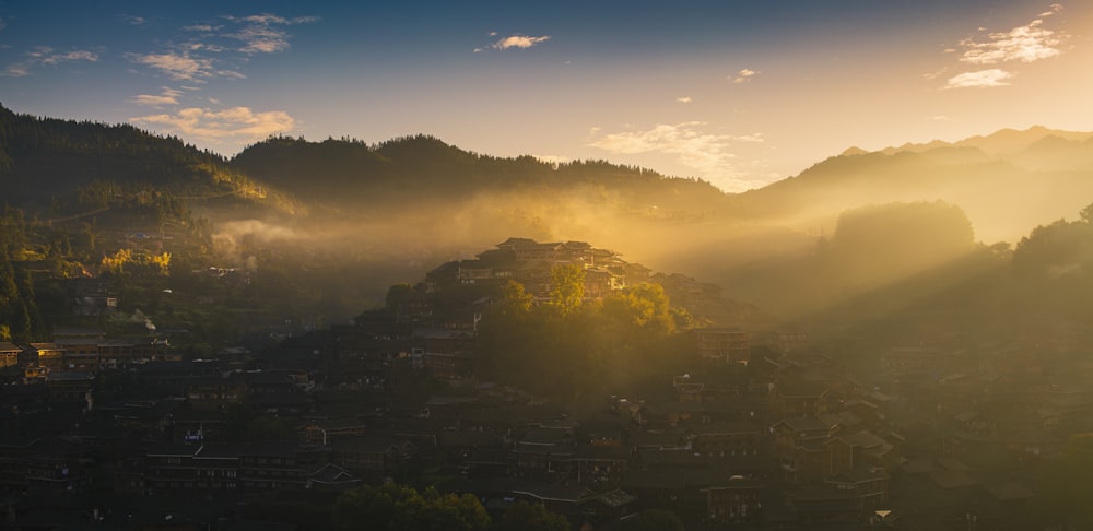 green trees and mountains during sunrise