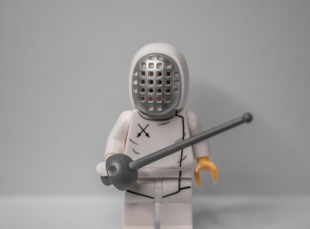 white robot toy holding a stick