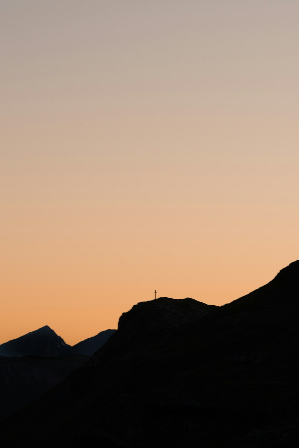 silhouette of person standing on rock formation during daytime