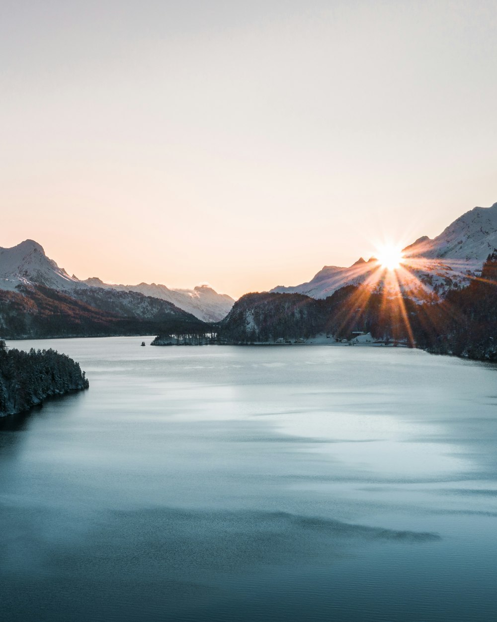 body of water near mountain during daytime