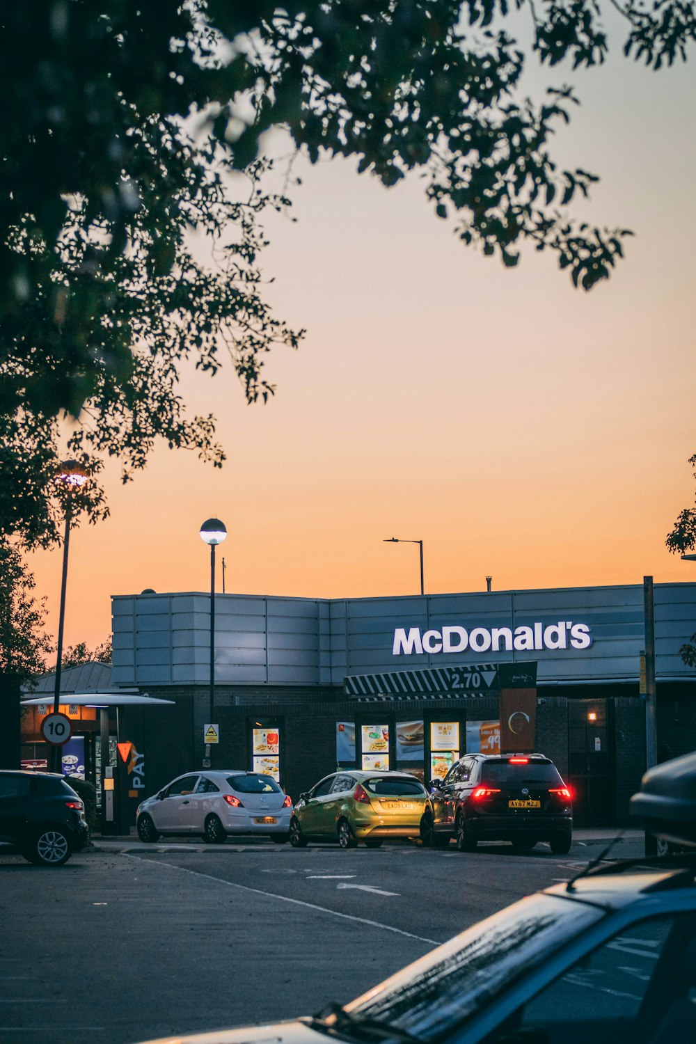 a mcdonald's restaurant with cars parked in front of it